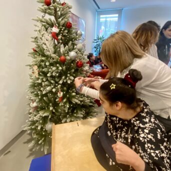 Children, trainers of Amymoni and volunteers of Praktiker Hellas decorate the Christmas tree.