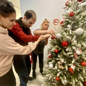 Children, trainers of Amymoni and volunteers of Praktiker Hellas decorate the Christmas tree.