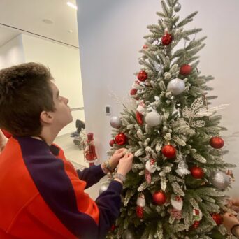 Children, trainers of Amymoni and volunteers of Praktiker Hellas decorate the Christmas tree.