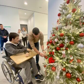 Children, trainers of Amymoni and volunteers of Praktiker Hellas decorate the Christmas tree.